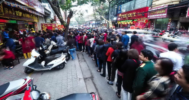 Lượng người đến mua tăng đột biến vào thời điểm sau 9 giờ sáng, dòng người tràn xuống lòng đường khiến tuyến phố Trần Nhân Tông bị ùn cục bộ - Ảnh: Nguyễn Khánh