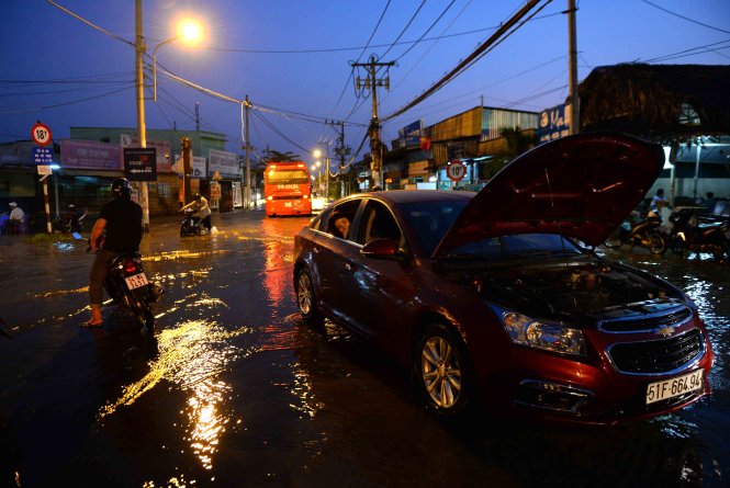 Một chiếc xe ô tô chết máy khi đi qua đoạn ngập nước trên đường Lê Văn Lương - Ảnh: HỮU KHOA