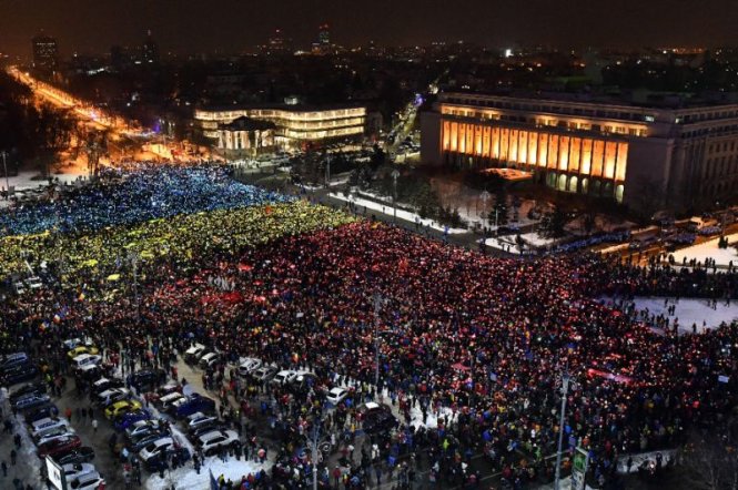 Người biểu tình tập trung trước trụ sở chính phủ tại Bucharest, phản đối một sắc lệnh về tham nhũng gây tranh cãi - Ảnh: AFP
