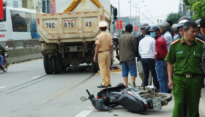 Hiện trường vụ tai nạn thương tâm: Chiếc xe tải kéo lê xe máy và cuốn cả ba người vào gầm xe - Ảnh: Trần Mai