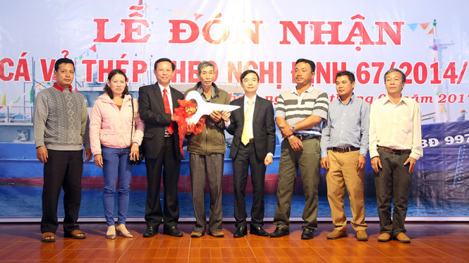 Lãnh đạo huyện Hoài Nhơn trao tượng trưng chìa khóa tàu vỏ thép cho các ngư dân - Ảnh: THÁI NGÂN
