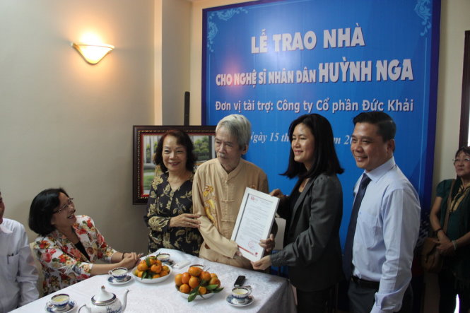 Đại diện công ty Đức Khải trao quyết định tặng nhà cho NSND Huỳnh Nga - Ảnh: Nguyễn Lộc