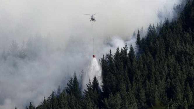 Trực thăng tưới nước xuống một đám cháy rừng ở Port Hills - Ảnh: AP