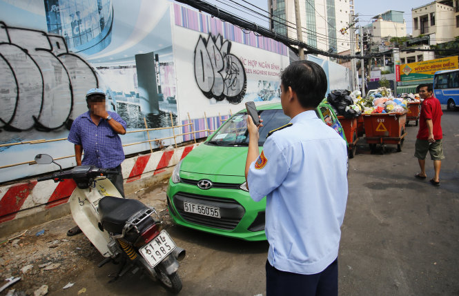 Nhân viên quản lý trật tự đô thị Q.1 (TP.HCM) ghi hình một người tiểu bậy trên đường Nguyễn Cư Trinh, Q.1 để làm bằng chứng xử phạt - Ảnh: Hữu Khoa