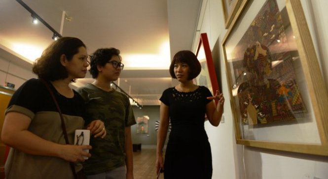 Bà Nguyễn Thị Phương Nhung (bìa phải) - giám đốc điều hành Real Art - hướng dẫn khách xem tranh tại Bảo tàng Mỹ thuật TP.HCM (Q.1) - Ảnh: DUYÊN PHAN
