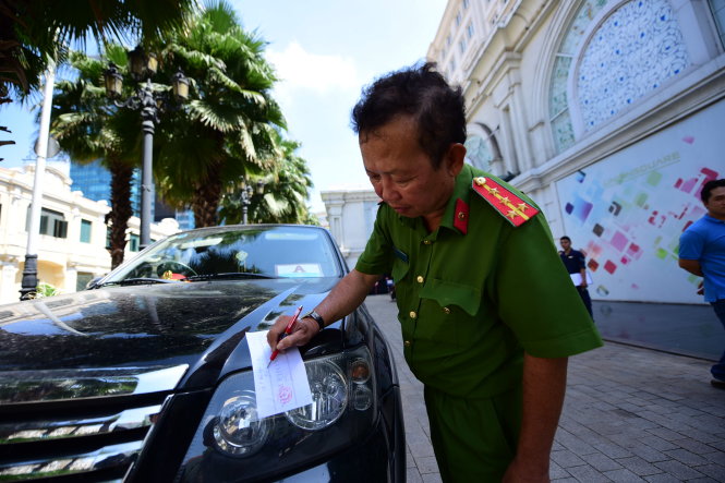 Một xe ô tô đậu trái phép trước cửa tòa nhà Union Square trên đường Lê Thánh Tôn, Q.1 bị dán niêm phong để xử phạt - Ảnh: Hữu Thuận