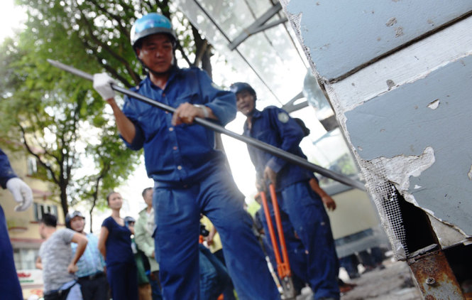 Lực lượng Dịch vụ công ích tháo dỡ trụ sở khu phố nằm án ngữ trên vỉa hè đường Nguyễn Trung Trực (Q.1, TP.HCM) - Ảnh: LÊ PHAN