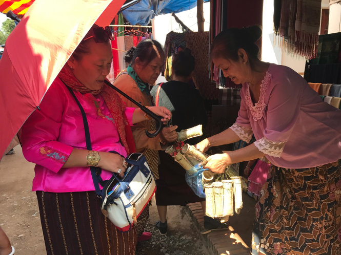 Cả người bán lẫn người mua đều hiền hòa tại một làng dệt truyền thống ở cố đô Luang Prabang - Ảnh: Q.Trung