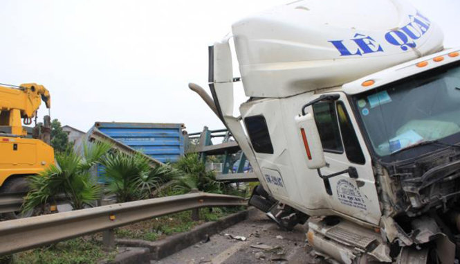 Chiếc xe container bị lật nằm ngang đường sau vụ tai nạn - Ảnh: Đình Thành