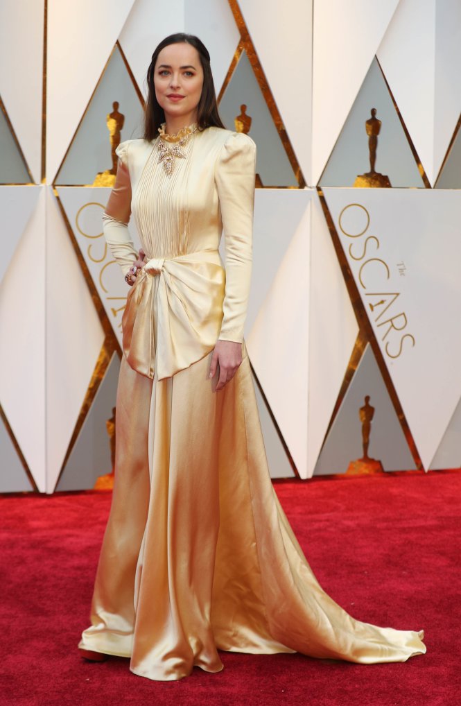 Ngôi sao Dakota Johnson với bộ đầm của Gucci trên thảm đỏ Oscar 2017 - Ảnh: Reuters