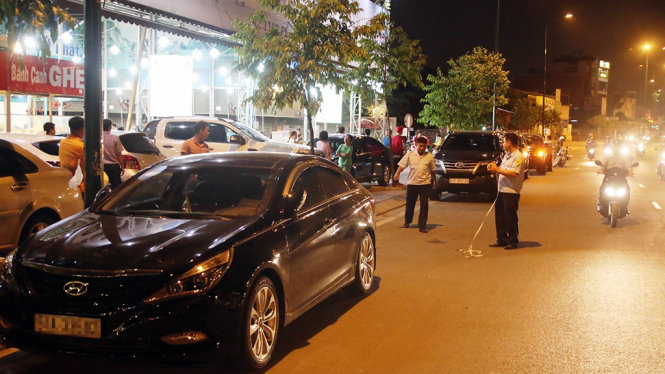 Hàng loạt xe 4 bánh đậu phía trên vỉa hè lẫn phía dưới lòng đường ở quán nhậu trên đường Phạm Văn Đồng - Ảnh: Tâm Đức