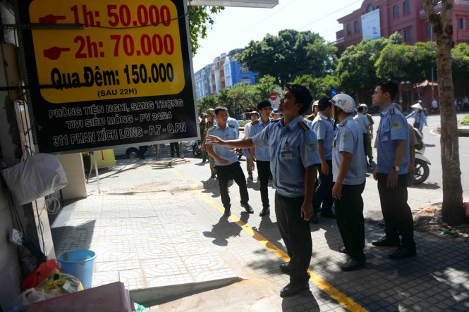 Nhiều biển hiệu khách sạn được lực lượng trật tự đô thị quận Phú Nhuận nhắc nhở tháo xuống trên đường Phan Xích Long - Ảnh: HỮU KHOA