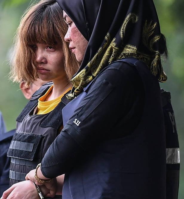 Cảnh sát dẫn giải Đoàn Thị Hương (trái) sau phiên tòa tại Malaysia. Đoàn Thị Hương đã được cho mặc thêm áo chống đạn - Ảnh: AFP