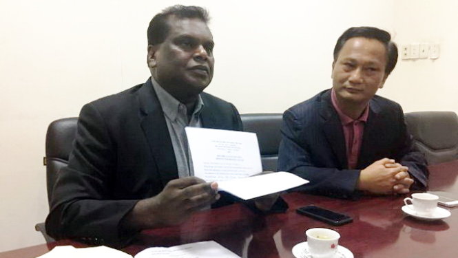 Luật sư Selvam Shanmugam (trái) cầm lá đơn của gia đình nhờ bào chữa cho Đoàn Thị Hương - Ảnh: Trần Phương