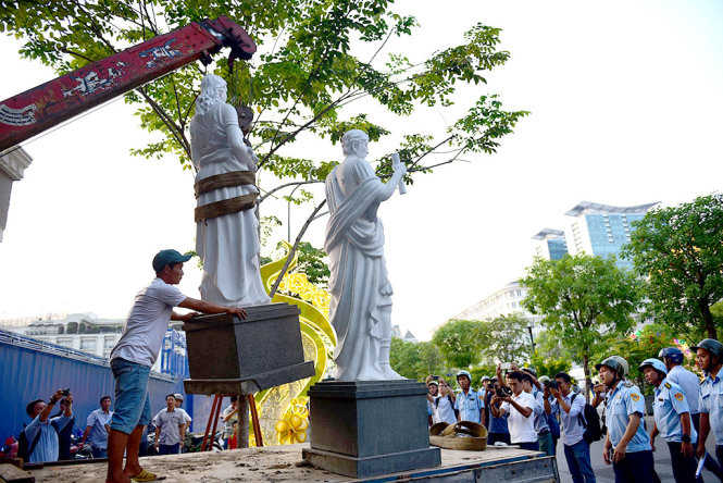 Những bức tượng đá trước khách sạn Royal trên đường Nguyễn Huệ, Q.1 bị lực lượng chức năng cẩu đi để xử lý do lấn chiếm vỉa hè - Ảnh: HỮU THUẬN