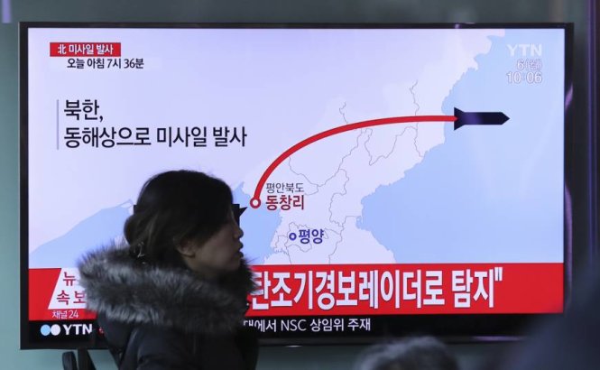 Một phụ nữ đi qua màn hình TV tại một nhà ga ở Seoul khi TV đang phát đi bản tin nói về vụ phóng 4 tên lửa của CHDCND Triều Tiên ngày 6-3 - Ảnh: AP