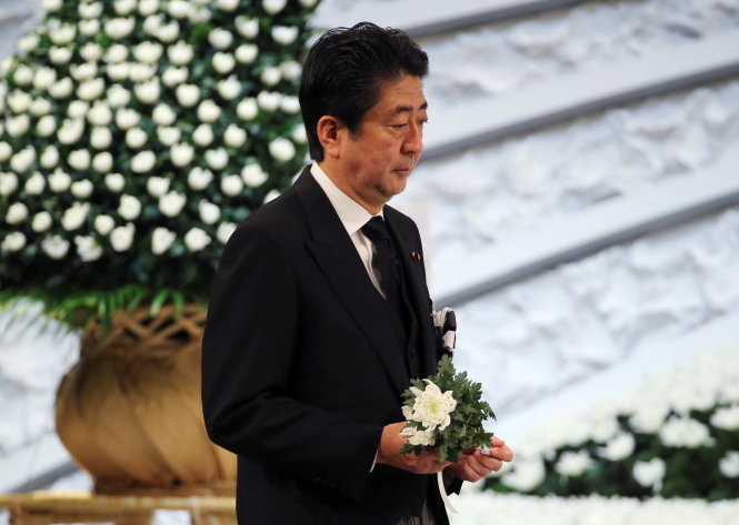 Thủ tướng Shinzo Abe đem theo hoa cúc trắng tưởng niệm các nạn nhân trong buổi lễ tại Tokyo ngày 11-3-2017 - Ảnh: Reuters