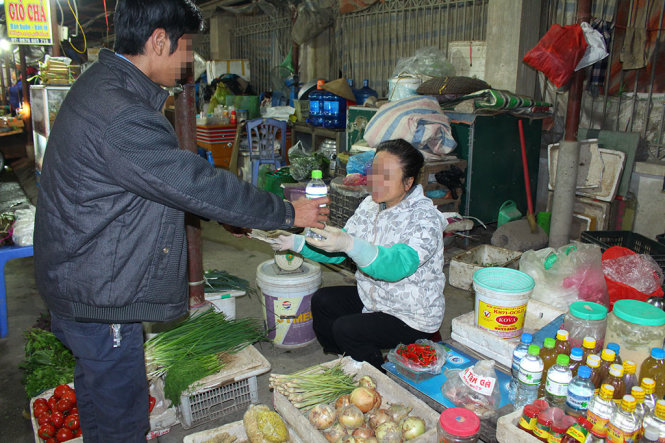 Sau nhiều vụ ngộ độc rượu có methanol dẫn đến chết người, rượu không có nguồn gốc và nhãn mác vẫn được bày bán ở chợ tại Hà Nội - Ảnh: Chí Tuệ