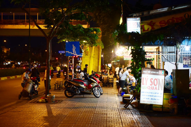 Một quán nhậu vẫn ngang nhiên lấn chiếm toàn bộ vỉa hè để buôn bán và để xe máy (ảnh chụp 6 giờ chiều 14-3) - Ảnh: Hữu Thuận