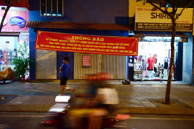 Nhiều tấm biển thông báo để tuyên truyền cho người dân xung quanh tuyến đường không lấn chiếm vỉa hè (ảnh chụp 7 giờ tối 14-3) - Ảnh: Hữu Thuận
