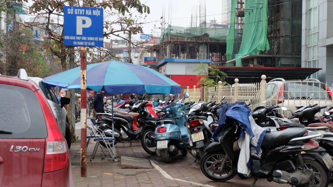 Một điểm trông giữ xe trên phố Hồ Tùng Mậu ngoài phạm vi được phép để xe trên vỉa hè vẫn lấn chiếm để xe kín vỉa hè - Ảnh: Xuân Long