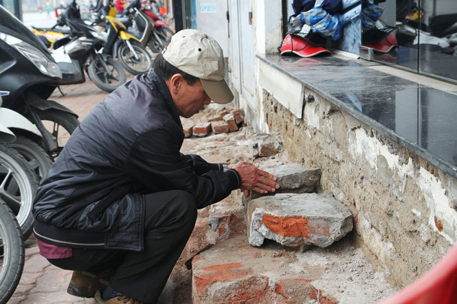 Người dân xếp những mảnh gạch từ bậc tam cấp bị phá bỏ để làm bậc đi lại tạm