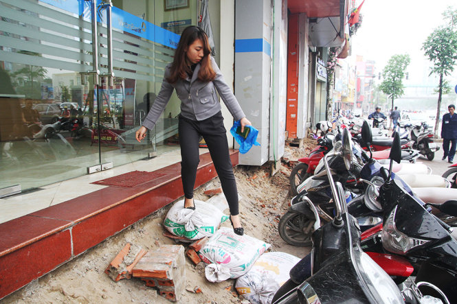 Một khách hàng cẩn trọng bước xuống các bậc bao tải từ một cửa hàng trên phố Xã Đàn