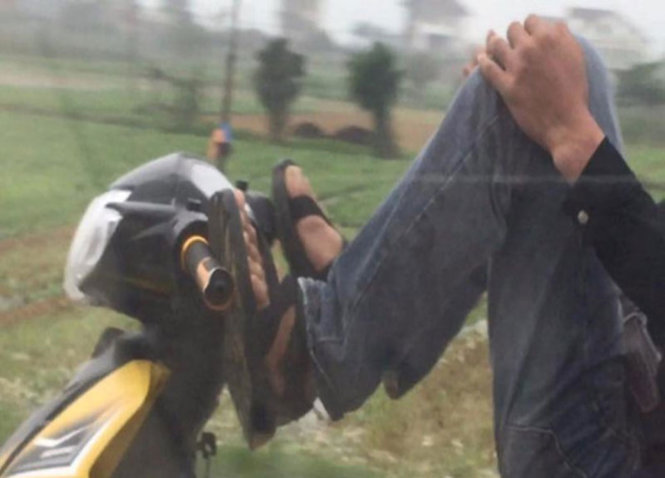 Hành vi lái xe máy bằng…chân khiến nhiều người bất bình - Ảnh: D.HÒA cắt từ video clip