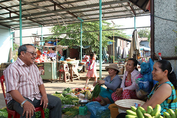 Ông Năm Hấp trò chuyện cùng những người buôn bán trong khu chợ mang tên ông trên đường T1 (Q.Tân Phú, TP.HCM) - Ảnh: LÊ PHAN