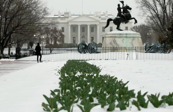 Du khách nghỉ chân trước hàng rào Nhà Trắng hôm 14-3 - Ảnh: Reuters