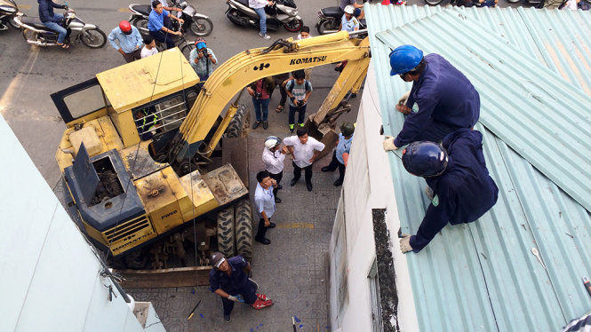 Nhân viên công ích quận 1 tháo dỡ mái tôn trụ sở khu phố lấn chiếm vỉa hè - Ảnh: Lê Phan