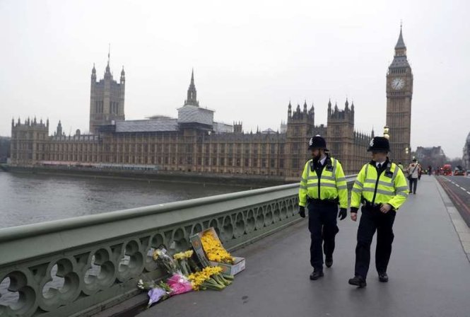 Đặt hoa tưởng niệm những người xấu số thiệt mạng trong vụ tấn công bằng xe trên cầu Westminster tại London, Anh - Ảnh: Reuters