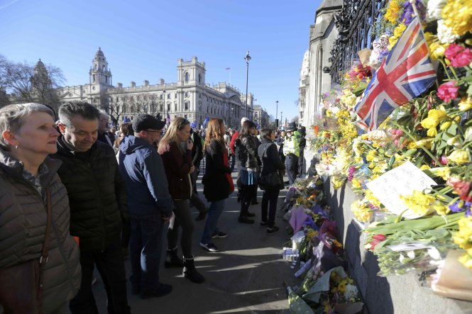 Người dân Anh đặt hoa trên tường quanh quốc hội Anh ngày 25-3 để tưởng niệm các nạn nhân vụ tấn công - Ảnh: Reutes