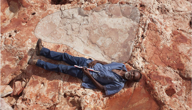 Một người nằm bên dấu chân khủng long khổng lồ 1,7m vừa tìm thấy - Ảnh: twitter Steve Salisbury
