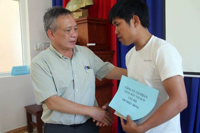 Ông Trương Ngọc Minh (trái) trao tiền ủng hộ một gia đình của thủy thủ tàu Hải Thành 26 - Ảnh: ĐÔNG HÀ
