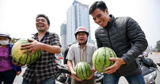 Ba người đàn ông vui vẻ khi chọn được những quả dưa hấu ưng ý để mua giúp người dân Quảng Ngãi - Ảnh: NAM TRẦN