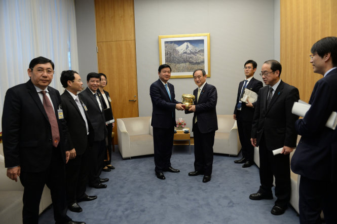 Đoàn đại biểu cấp cao TP.HCM tặng trống đồng cho ông Yoshihide Suga Chánh văn phòng nội các Nhật Bản - Ảnh: THUẬN TAHWNGS