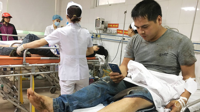 Anh Bùi Mạnh Kiểm (30 tuổi, quê Thái Bình) bị thương sau vụ tai nạn gọi điện thoại cho người thân - Ảnh: DOÃN HÒA