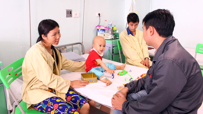 Cháu Nguyễn Minh Hiếu (26 tháng tuổi) đang điều trị u não hồn nhiên đùa nghịch với các cô chú xung quanh phòng bệnh - Ảnh: HÀ THANH