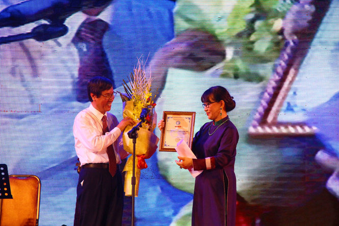 GS.TS Cao Ngọc Thành, hiệu trưởng Trường ĐH Y dược – ĐH Huế tặng hoa đến đại diện gia đình nhạc sĩ Trịnh Công Sơn - Ảnh: MINH AN