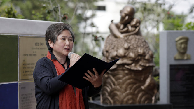 Một vị đại biểu Hàn Quốc đọc những bài thơ hòa bình trước tượng Pieta Việt Nam - Ảnh: Woohae Cho