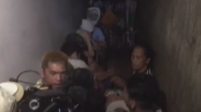 Phương tiện truyền thông quay lại cảnh các tù nhân được phát hiện trong nhà giam sau kệ sách ở đồn cảnh sát tại Manila - Ảnh: ABS-CBN