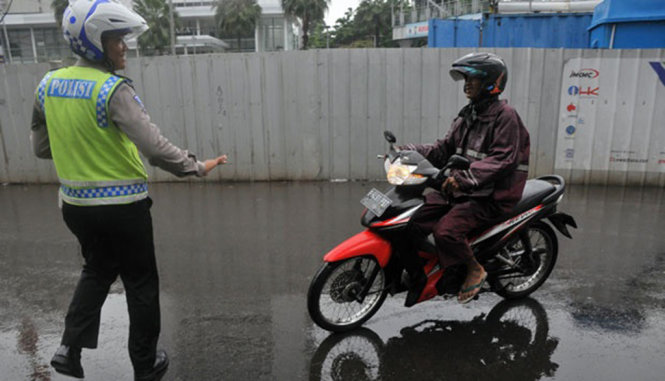 Cảnh sát chặn một xe gắn máy tại Jakarta, Indonesia - Ảnh: Tempo