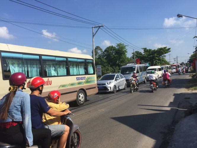 Đến 9g ngày 30-4, dòng xe vẫn xếp hàng, kéo dài khoảng hơn 5km từ bến phà vào trung tâm thị trấn huyện Lấp Vò, tỉnh Đồng Tháp - Ảnh: MẬU TRƯỜNG