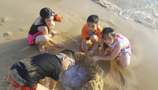 Bốn du khách nhí nghịch cát ven bờ biển resort Vinpearl Phú Quốc - Ảnh: K.NAM