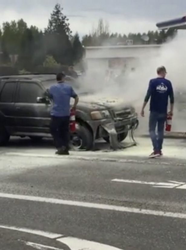 Lính cứu hỏa dập lửa cho một chiếc xe bị ảnh hưởng trong vụ rơi máy bay - Ảnh: FOX