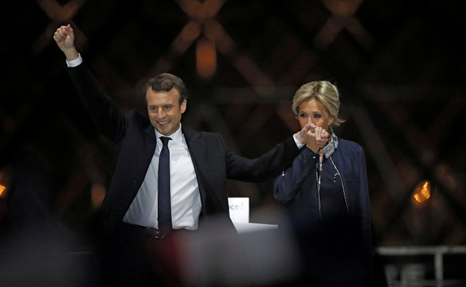 Ông Emmanuel Macron cùng vợ ông, bà Brigitte Trogneux chia sẻ niềm vui chiến thắng với những người ủng hộ tại một sự kiện gần Louvre, Paris, Pháp ngày 7-5 - Ảnh: Reuters