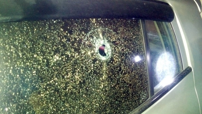 Vết thủng trên kính ô tô đậu ở cổng Bệnh viện đa khoa Hùng Vương sau khi bị nhóm thanh niên dùng vật nghi là súng cao su bắn vào hôm 7-5 - Ảnh: BVCC