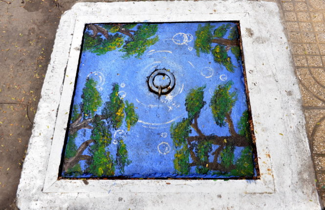 Một chiếc nắp cống được trang trí như một bức tranh phong cảnh trên đường Triệu Quang Phục (Q.5, TP.HCM) - Ảnh: DUYÊN PHAN