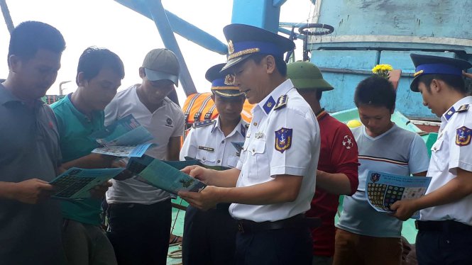 Cảnh sát biển phát tờ rơi và lưu ý với bà con ngư dân đánh bắt đúng trên vùng biển chủ quyền Việt Nam - Ảnh: Đông Hà